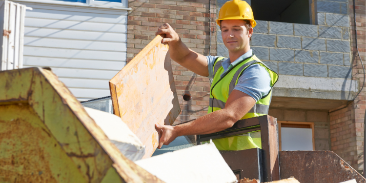 builder putting rubbish into a skip
