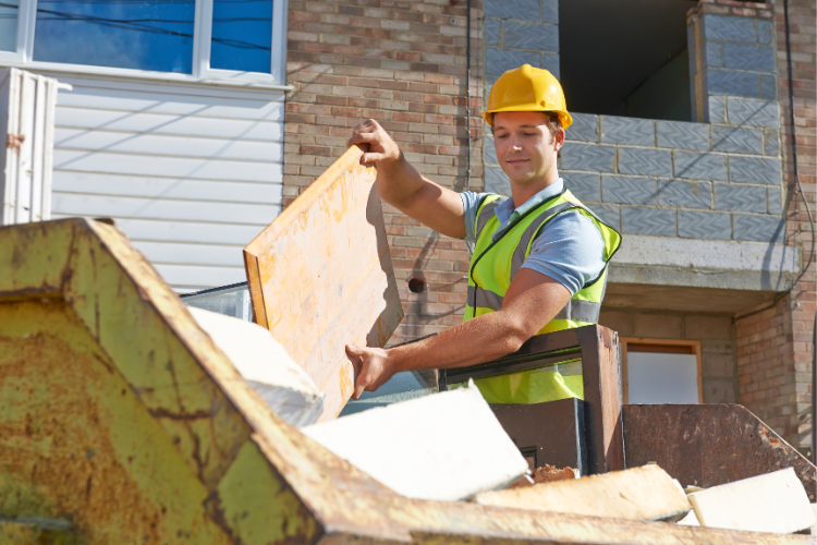 builder putting rubbish into a skip